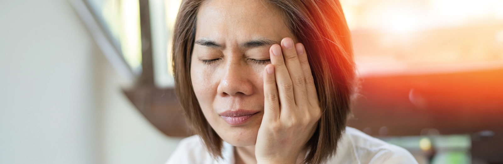 woman-holding-her-jaw-in-pain-1600x522.webp