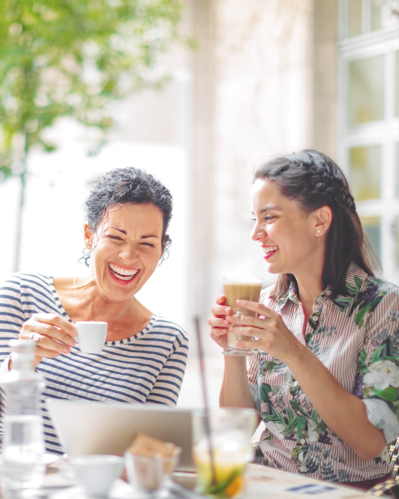 women-laughing-while-drinking-coffee-800x1000.webp